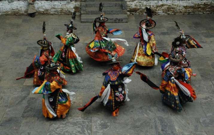 Zhanag, Black Hat sorcerer dancers, Yungdrung Choeling Dzong, Trongsa, Bhutan, 2006. Note the ancient mask on the dancers’ aprons. The gyroscopic dancing drives the moving mask face into a patterned frenzy. Here the face is the yiddam deity Mahakala. Like the Liagzhu jade, the sorcerer appears to ride the protective deity. Photo by Gerard Houghton for Core of Culture
