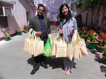 Pilgrims with bags containing Buddha robes made by village women in Bodhgaya. From: L. Sum 2012