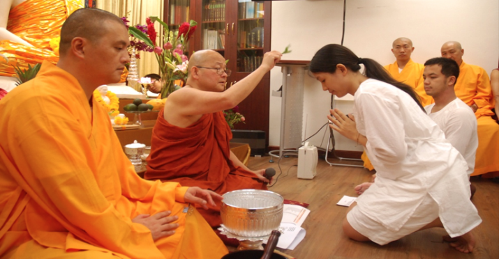 Ven. Prof. K. L. Dhammajoti sprinkling blessed water on the head of a new <i>upasika</i> who has taken refuge. 2015. Image courtesy of Sara Li