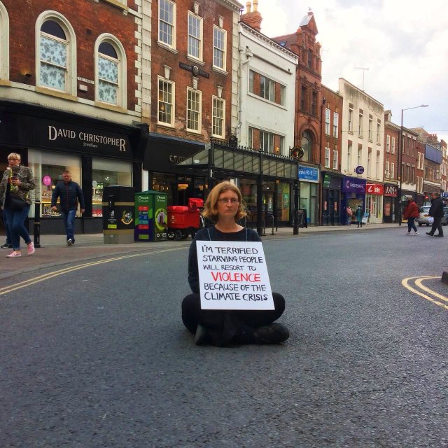 Satya Robyn in road holding sign