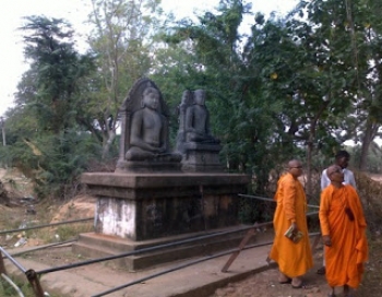 Ven. Suniti stands closest to a pair of statues. From Awakening Women.