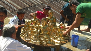Buddhist children and devotees bathing Buddha statues, Rangamati. Photo: Jnan Nanda