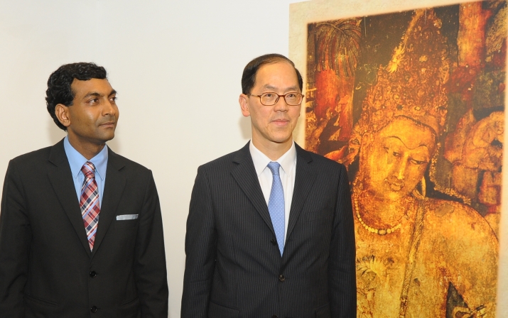 Mr. Agrawal admires his work with Tsang Tak-sing behind him. From the Indian Consulate in Hong Kong