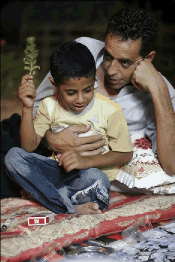 Ismael holds Ahmed close, who was shot dead while playing with a toy gun. From Expatica.com.