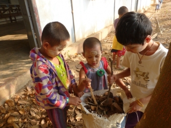 Children gathering dried leaves on Sunday at Parahita Monastery