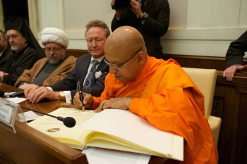 The Most Venerable Dhammaratana signs the Declaration of Religious Leaders against Slavery on 2 December 2014. From globalfreedomnetwork.org