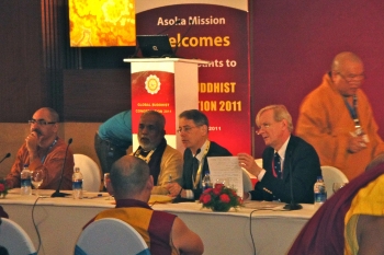 IBC discussion panel members: Kishore Thukral (far left), Gregory Kruglak (seated, 2nd from right, Patrick Gaffney (seated, far right), Ven. Thich Quang Ba (walking rear right)