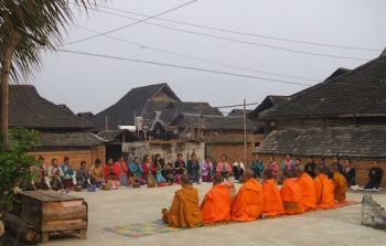monks receiving alms from village community