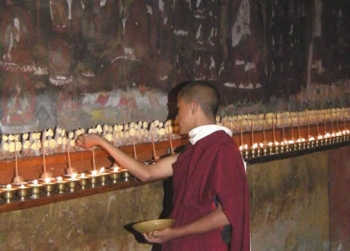 Lighting butter lamps before the 16th-century wall paintings of Tamshing Monastery, Bhutan . Photo: Research Project on the Wall Paintings of Bhutan (Courtauld Institute and the Department of Culture of Bhutan) 2009