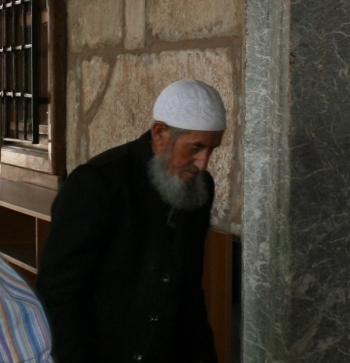 Elderly practitioner entering Alaeddin Camii in Ankara Castle
