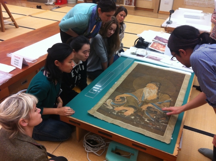 Students in the Master's of Buddhist Art and Conservation program studying a work of Chinese Buddhist art. From The Robert H. N. Ho Family Foundation Centre for Buddhist Art and Conservation