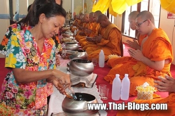 Thai lay practitioners offering honey to monks. From thaibuddhist.com