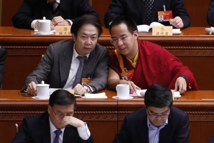 Gyaltsen Norbu, right, speaks with a delegate at the opening of the third plenary meeting of the Chinese People’s Political Consultative Conference in March. From reuters.com
