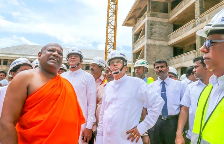Ven. Dr. Bodhagama Chandima Thero, left, executive director of the university and chief incumbent of Manelwatta Viharaya, shows visitors around the site of the new institution. From dailynews.lk