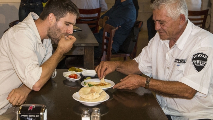 An Israeli Jew and Muslim Arab-Israeli share a plate of hummus at the Hummus Bar, an Israeli restaurant near the coastal city of Netanya that offers a 50 per cent discount on hummus plates to Arabs and Jews who sit at the same table. From egyptianstreets.com
