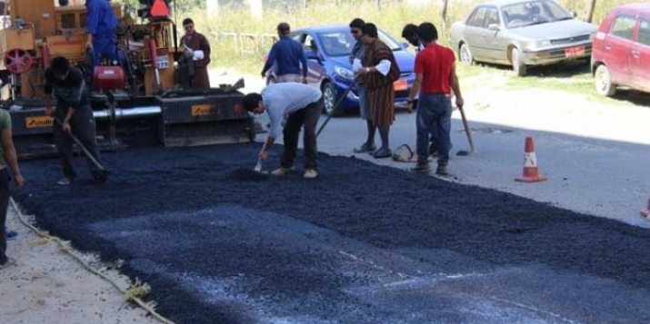 In a pilot run, Green Road project employees surface a road in Thimpu with plastic-infused bitumen. From kuensel online.com
