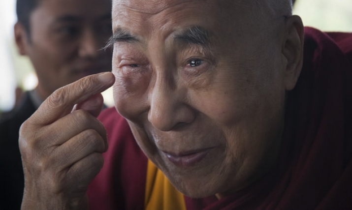 The Dalai Lama gestures to his swollen right eye as he talks to journalists before boarding his flight in Dharamsala, India on Tuesday. From dailymail.co.uk