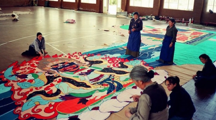 Tibetan women working on the giant <i>thangka</i>. As the image grew in size, a gymnasium was used to assemble the completed parts. Image courtesy of Leslie Nguyen Temple