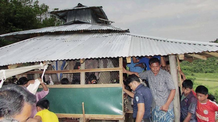 Local residents look on as police inspect the temple where Buddhist monk Mong Shwe U Chak, 75, was killed. From dhakatribune.com