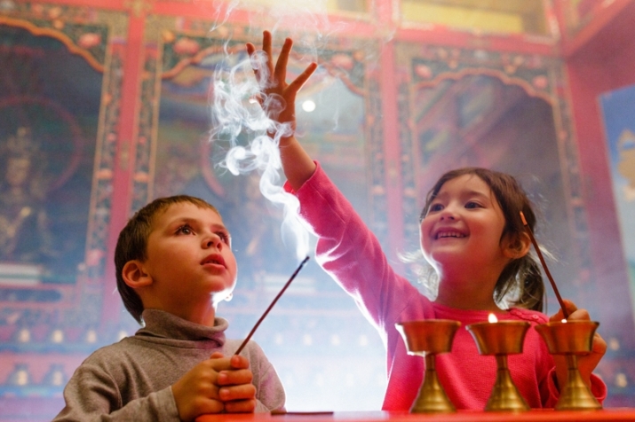 Amaya and her friend offering incense and butterlamps in the Khadro Ling shrine room. Photo by Pedro Rocha