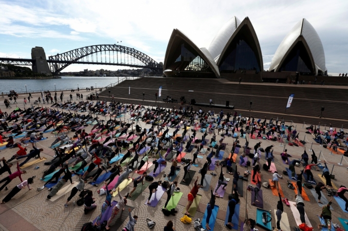 Hundreds participate in a mass yoga event in front of Sydney Opera House. From wsj.com