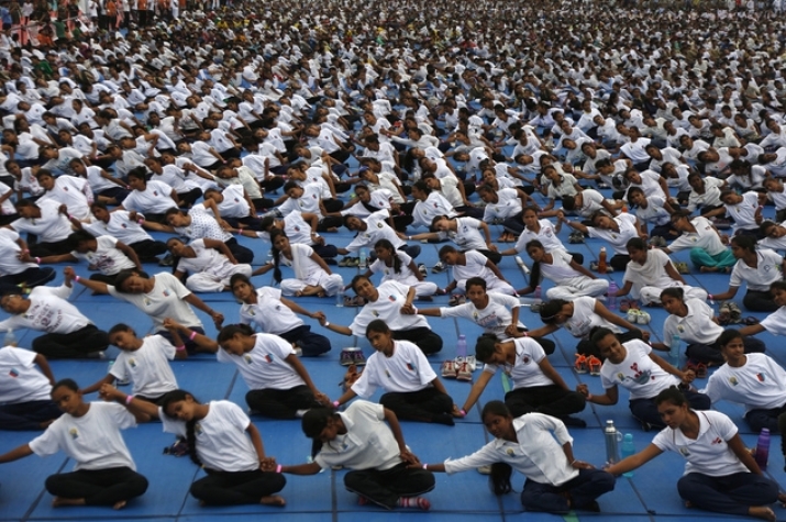 More than 8,000 people hold hands in Ahmadabad, India, as they attempt to create a record for the longest human yoga chain during International Day of Yoga. From dailymail.co.uk