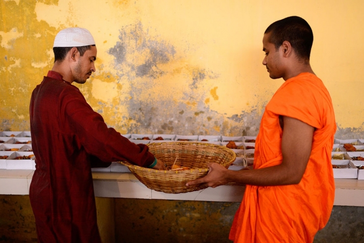 Local Muslim resident Sujam and Buddhist monk Dipananda Bhikkhu prepare the <i>iftar</i> food boxes. Photo by Mahmud Hossain Opu. From aljazeera.com