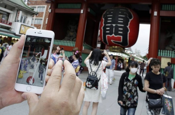 Since its launch in Japan on 22 July, the mobile game <i>Pokémon Go</i> has exploded in popularity. Here, a man plays in front of Kaminarimon Gate at the temple Senso-ji in Tokyo's Asakusa District. From japantimes.co.jp