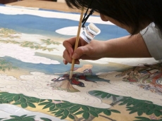 A conservator consolidates the scroll's pigments. From hyperallergic.com