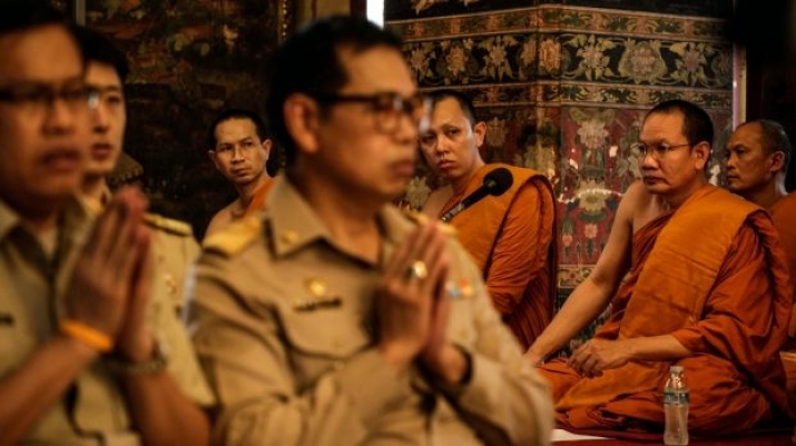Buddhist monks and government officials pray for the king at Wat Pathumwanaram. From smh.com.au