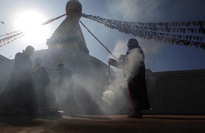 A monk carries incense around the stupa. From thehimalayantimes.com