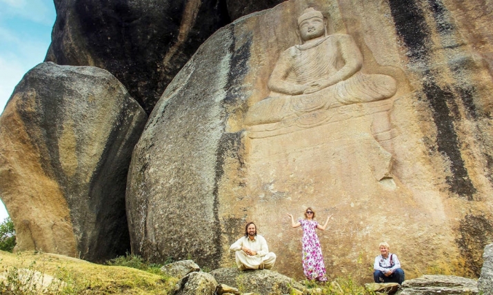 Russian tourists beneath the newly restored Buddha image. From lionsroar.com