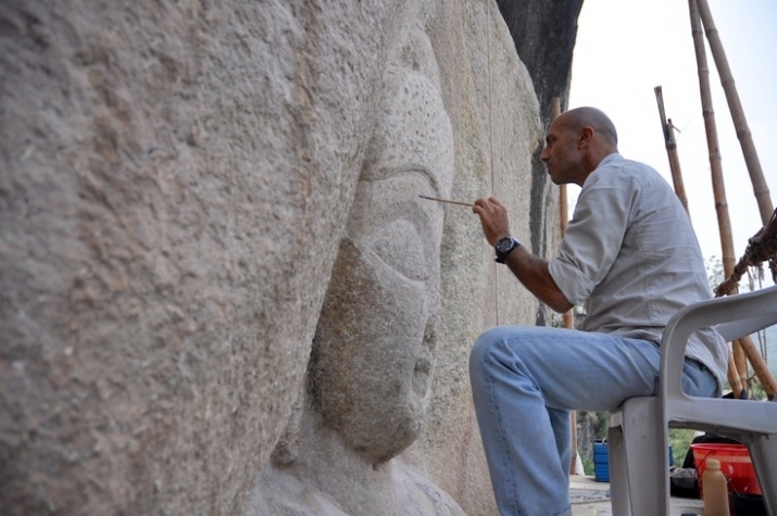 Conservator Fabio Colombo puts the final touches to his restoration of the Buddha's face. From lionsroar.com