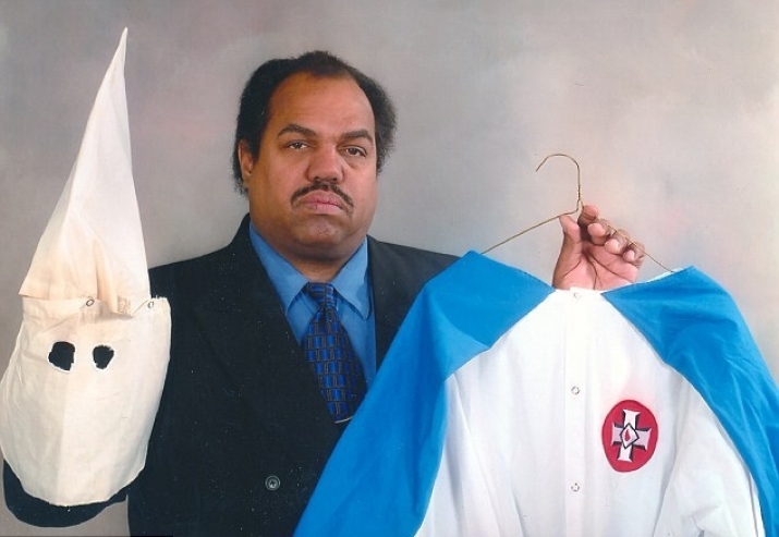 Daryl Davis holds up the distinctive white robe and face mask of a Ku Klux Klan member. From dailymail.co.uk