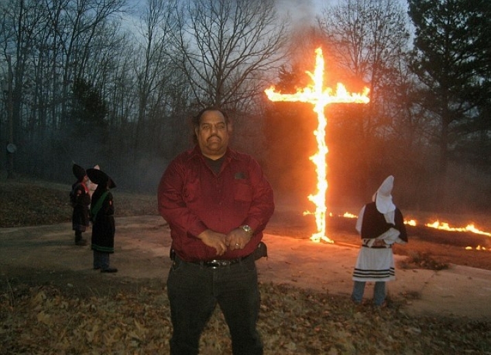 Davis stands near a burning of the cross ceremony with KKK members. From dailymail.co.uk