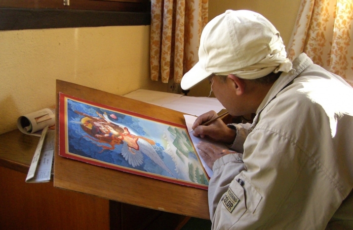Udaya Charan Shrestha finishing a <i>paubha</i> of Sarasvati. Image courtesy of the author