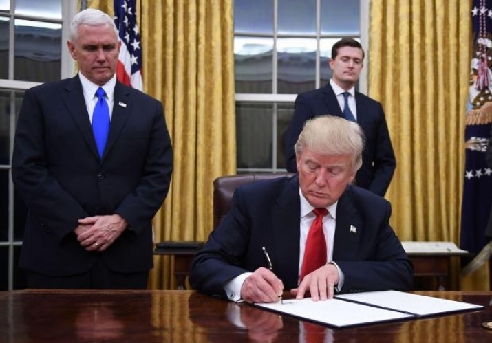 Donald Trump signs an executive order on 20 January 2017. From independent.co.uk