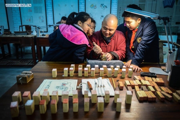 Wei Lizhong demonstrates woodblock printing techniques to students at his studio in Hangzhou. From xinhuanet.com