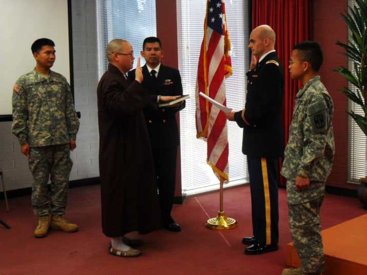 Venerable Guan Zhen placing his hand on the <i>Vimalakirti Sutra</i> and swearing an oath at his commissioning ceremony. From buddhistmilitarysangha.blogspot.com