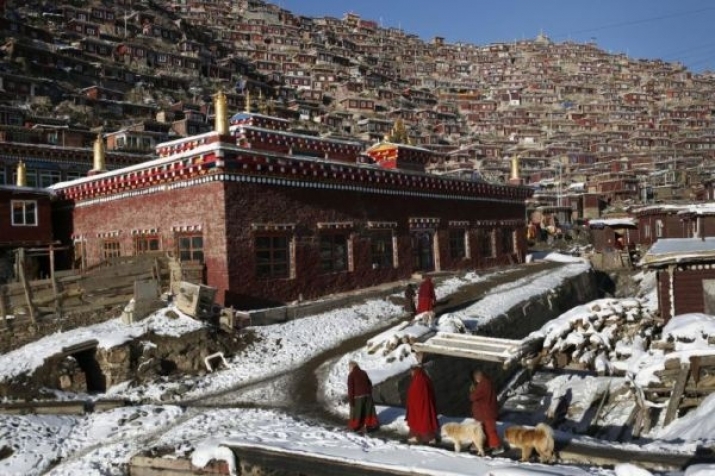 Tibetan nuns walk by houses and monastery buildings at Larung Gar in 2009. From newsday.com