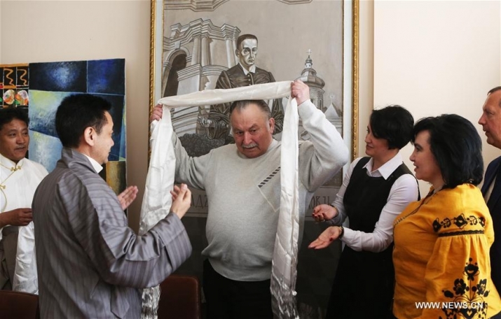 Zheng Dui, second left, offers a <i>hada</i> to Anatoly Kolodny, third left, during the roundtable discussion. From xinhuanet.com