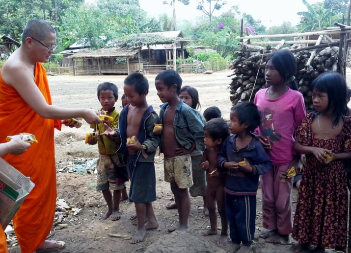 Ajahn Saneh hands out biscuits to children during a visit to Myanmar's Shan State.