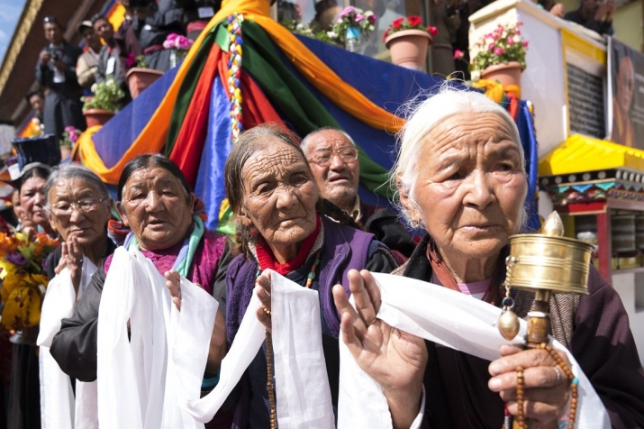 Well-wishers in traditional Tibetan dress line the road to the Jokhang in Leh. From dalailama.com