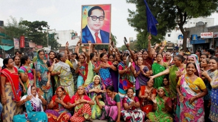 Members of the Dalit community hold aloft an image of Dr. Ambedkar. From dnaindia.com