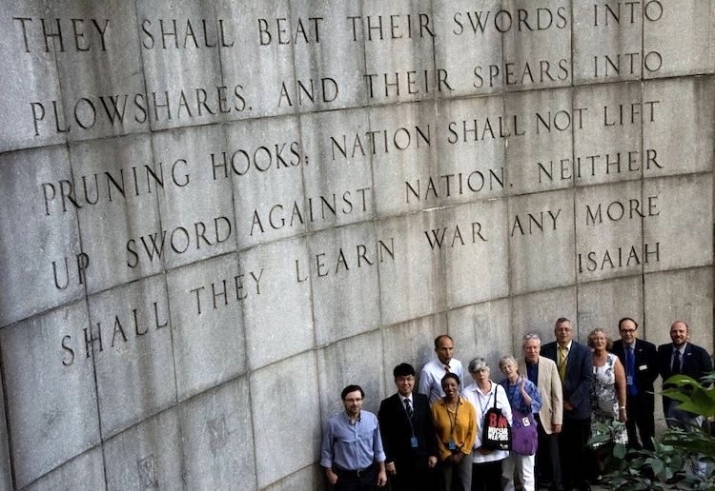 Faith group representatives stand in front of the Isaiah Wall across the street from the United Nations Building in New York City. From indepthnews.net