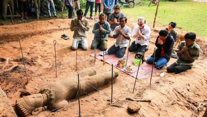 The archaeological team holds a religious ceremony to ask the spirits protecting the site for permission to move the statue. From cambodiadaily.com