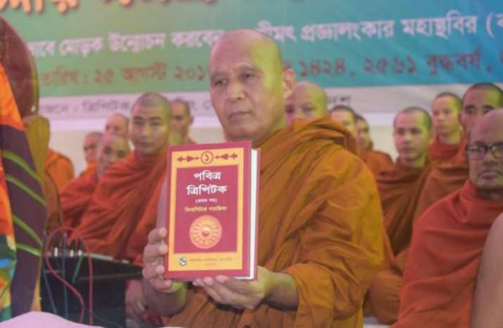 Chief Abbot of Rajban Bihar, Venerable Pragyalankar Mahasthvir, unveils the <i>Pabitra Tripitaka</i>. From dhakatribune.com