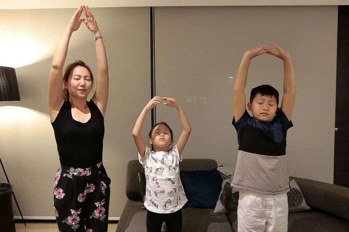 Ms Lim Yu Lin doing a mindfulness breathing exercise with her children, Isabel and Leon. From straitstimes.com