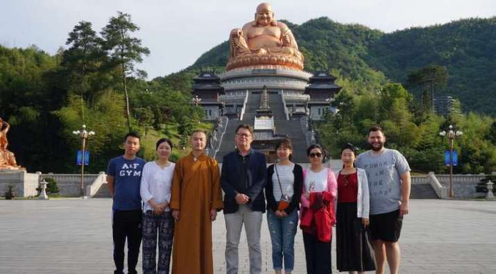 In front of the statue of Maitreya Buddha at Xuedou (Snow Pass) Monastery with the abbot, UA’s Prof. Albert Welter, and UA graduate students. From uanews.arizona.edu