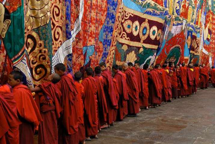 Monks at Punakha Tsechu, Bhutan, unrolling a thangka representing the Shabdrung, for a yearly festival. From bhutanrebirth.com